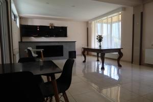 a living room with a table and a fireplace at Hotel Marli in Arsha