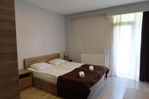a bedroom with a large bed with white pillows at Hotel Marli in Arsha