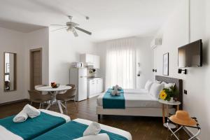 a hotel room with two beds and a kitchen at Villa Collina in Giardini Naxos