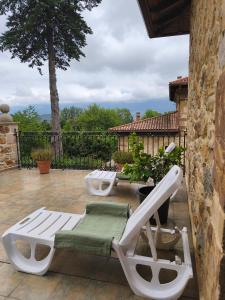 two white lounge chairs on a patio at Casa Mi Capricho in Concejero