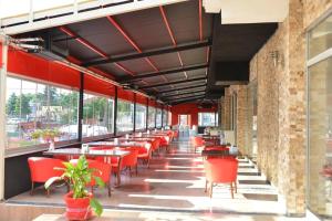 a restaurant with red chairs and tables and windows at Grand Beyaz Saray Otel in Duzce