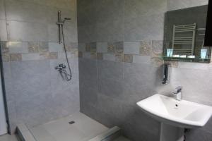 a bathroom with a sink and a shower and a toilet at Hotel Marli in Arsha +35 photos