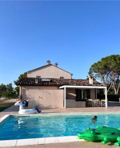 ein Swimmingpool mit einer Schwimmnudel vor einem Haus in der Unterkunft Relais Villa Sofia in Calcinelli
