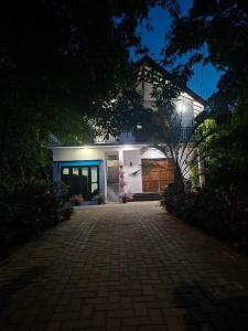 a white house with a driveway in front of it at Emerald Mirror in Anuradhapura