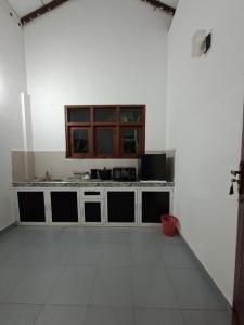 a kitchen with white walls and a counter top at Emerald Mirror in Anuradhapura