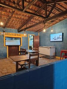 a room with a table and chairs and a tv at Recanto Das Marés in Jacumã +7 photos