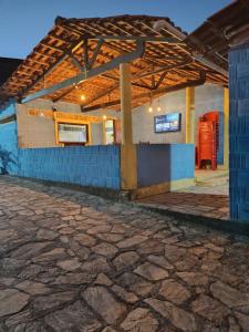 a building with a roof with a stone floor at Recanto Das Marés in Jacumã