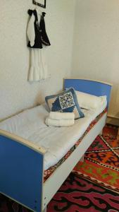 a bed in a room with a dress hanging on the wall at Akmuz House in Ak-Muz