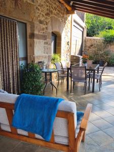 a patio with chairs and a table with a blue blanket at Casa Mi Capricho in Concejero