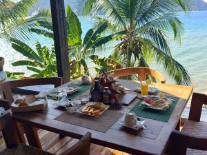 a table with food on it with a view of the ocean at Guest House Antsakoa in Nosy Komba