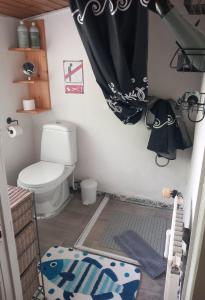 a bathroom with a toilet and a black curtain at Villa Sommersted Tanja Blixen in Sommersted