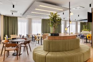 a restaurant with tables and chairs and a round table at B&B HOTEL Madrid San Fermin in Madrid