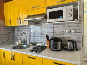 a kitchen with a stove and a microwave and a sink at домик у самого моря in Odesa