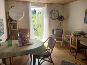 a dining room with a table and chairs and a clock at Villa Sommersted Tanja Blixen in Sommersted