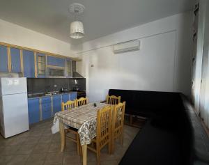 a kitchen with a table and chairs and a white refrigerator at David’s apartments in Hamallë