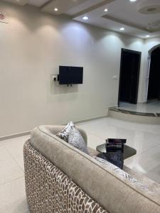 a couch in a room with a tv on a wall at كازا in Taif