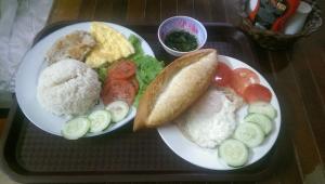 - un plateau avec deux assiettes de nourriture sur une table dans l'établissement Thao Nguyen Phat Homestay, à Hội An