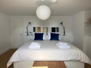 a bedroom with a large white bed with blue pillows at The Old Manse, Horton in Horton