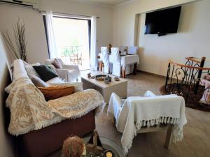 a living room with a couch and a tv at House M A R Y in Pefkali