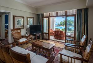 a living room with a television and a table and chairs at Reef Oasis Beach Aqua Park Resort in Sharm El Sheikh