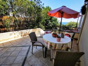 a table and chairs with an umbrella on a patio at House M A R Y in Pefkali