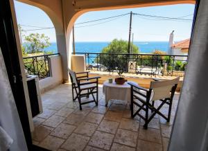 a patio with a table and chairs and a view of the ocean at House M A R Y in Pefkali