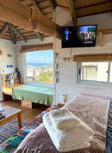 a bedroom with a bed and a tv on the wall at Casa Papaya in Punta Del Diablo