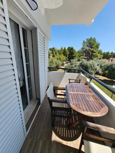 a balcony with a wooden table and chairs on it at Villa Askamnia and Suites in Nikiti