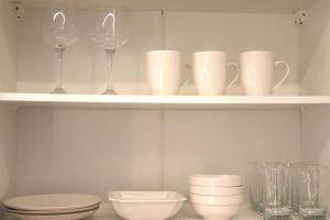 a shelf with wine glasses and plates and a toilet at Dany's studio central xanthi in Xanthi