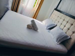 a bed with two pillows and a towel on it at MahaliaLuxuryStays in Malindi