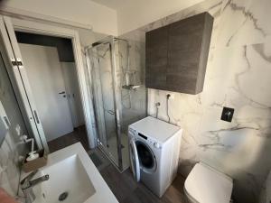 a bathroom with a washing machine and a toilet at bilocale con NETFLIX INCLUSO in Lodi
