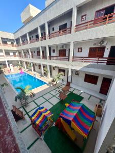 an apartment building with a swimming pool and two umbrellas at Residencial Ibiapaba FLAT 31 - com piscina e ótima localização in Camocim