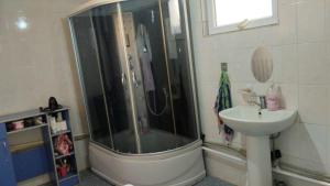 a bathroom with a shower and a sink at Akmuz House in Ak-Muz