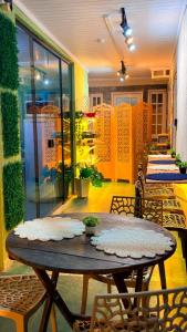 a patio with a table and chairs and a room with plants at Ninho Moderno in Volta Redonda