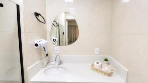 a bathroom with a sink and a mirror at Flat Premium a 500m do aeroporto Santos Dumont & Consulados in Rio de Janeiro