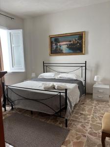 a bedroom with a bed with a painting on the wall at Residence Prato in Trapani