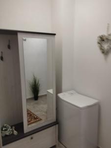a bathroom with a mirror next to a toilet at Solid House - Sunrise Apartment in Mamaia