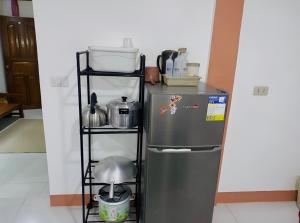 a kitchen with a metal refrigerator and a shelf at Queen's Guest House in El Nido