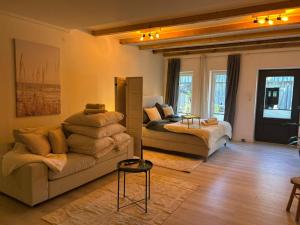 a living room with a couch and a bed at Kleine Auszeit - Urlaub auf dem Bauernhof in Immenstedt