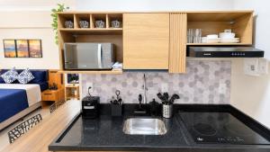 a small kitchen with a sink and a microwave at Flat Premium a 500m do aeroporto Santos Dumont & Consulados in Rio de Janeiro