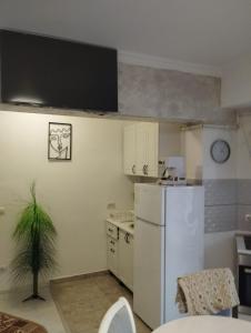 a kitchen with a white refrigerator and a table at Solid House - Sunrise Apartment in Mamaia