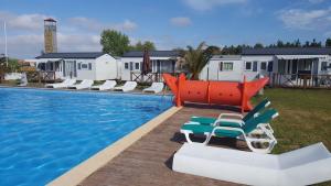 a swimming pool with lounge chairs and a swimming pool at Vickys Walls Bungalow in Pataias