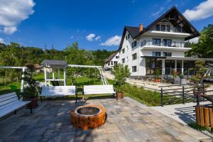 eine Terrasse mit zwei Bänken und ein Gebäude in der Unterkunft Arhondaric in Rucăr