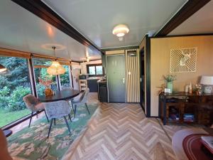 a living room with a table and chairs and a kitchen at 'De Schuif' in Berlicum