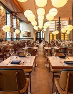 a restaurant with wooden tables and chairs and lights at Charlie Hotel in Kakani