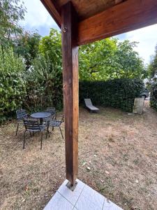 a wooden pergola with a table and chairs at Pavillon Le Luc in Ozillac
