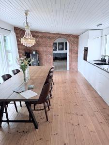 a dining room with a wooden table and a brick wall at Det lille hus in Viborg