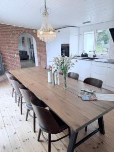 a large wooden table in a kitchen with chairs at Det lille hus in Viborg +5 photos