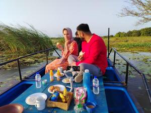 a man and a woman sitting on a boat at Three Tree Villa By Habarana in Habarana