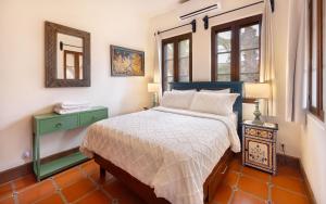 a bedroom with a bed and a mirror and windows at Casa Perla de Todos Santos in Todos Santos +50 photos